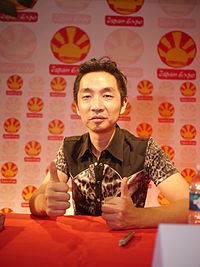 Photo of a Japanese man in a black jacket in front of a black background.